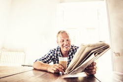 Man holding a drink and reading a paper